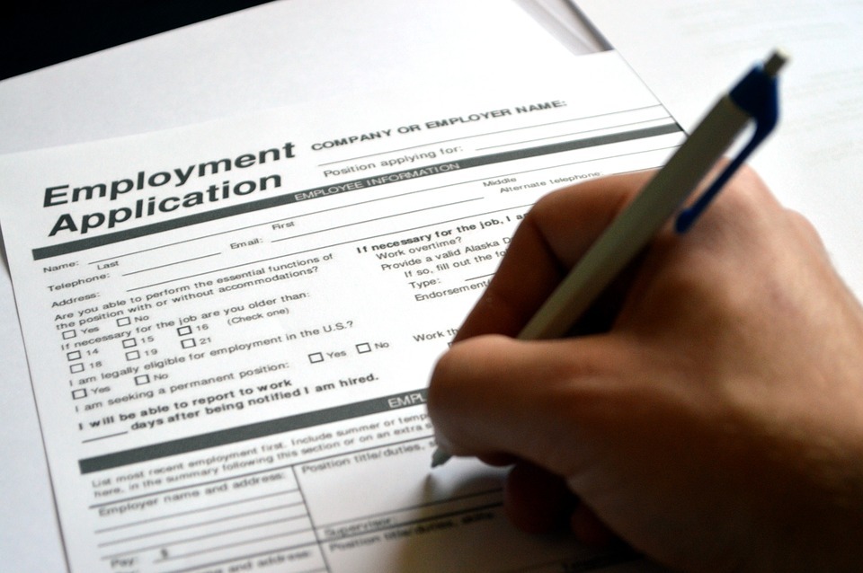 A Person Filling up an employment application form