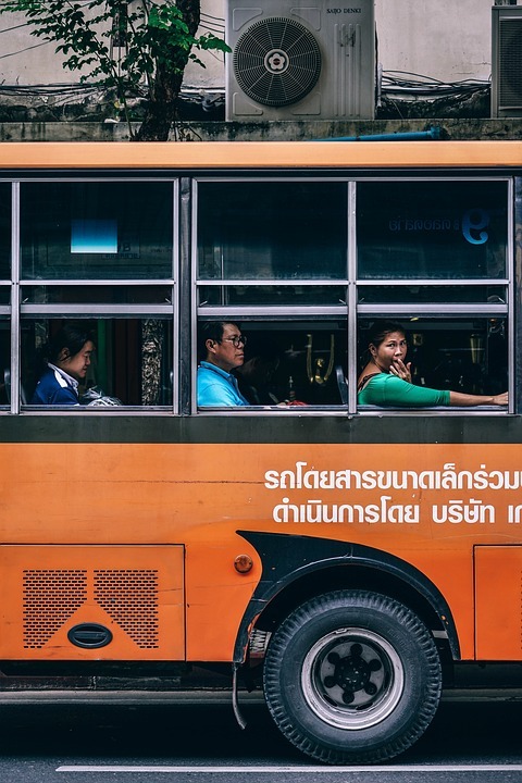 People Riding in an Orange Bus in Thailand