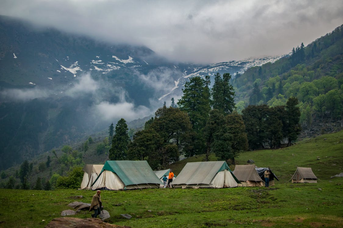 camping tents in front of mountains and trees