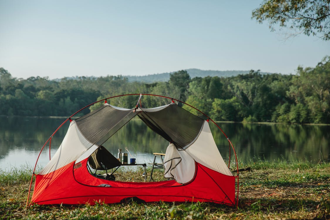 tent on the lakeside with camping chairs